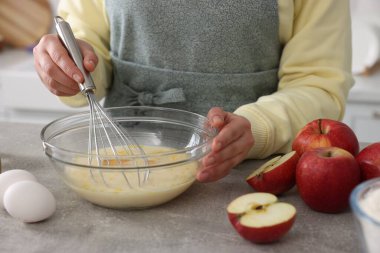 Gri masada yumurta çırpan kadın, yakın plan.