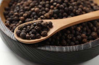 Aromatik baharat. Siyah biber kasede ve kaşık beyaz masada, yakın plan.