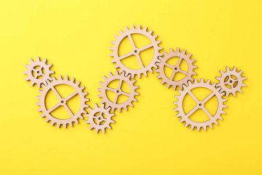 İş süreci organizasyonu ve optimizasyonu. Sarı arka planda ahşap figürlü şema, üst görünüm