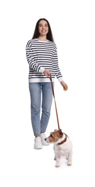 Gülümseyen kadın beyaz arka planda köpeğini gezdiriyor.
