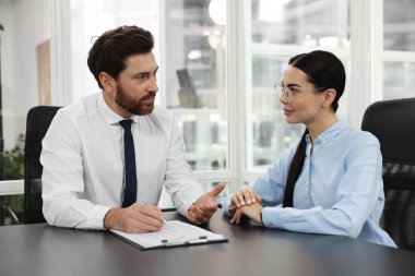 Elinde dosya olan avukatlar ofiste birlikte çalışıyorlar.