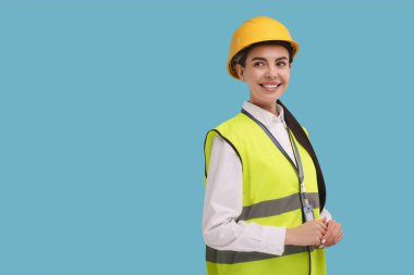 Açık mavi arkaplanda sabit şapka ve rozetli mühendis, metin için boşluk