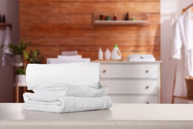 Çamaşır odasındaki ışık masasında temiz havlular, mesaj için yer.