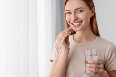 Evde vitamin hapı alan güzel bir genç kadın. Metin için boşluk