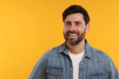 Sarı arka planda gülen yakışıklı bir adam. Metin için boşluk
