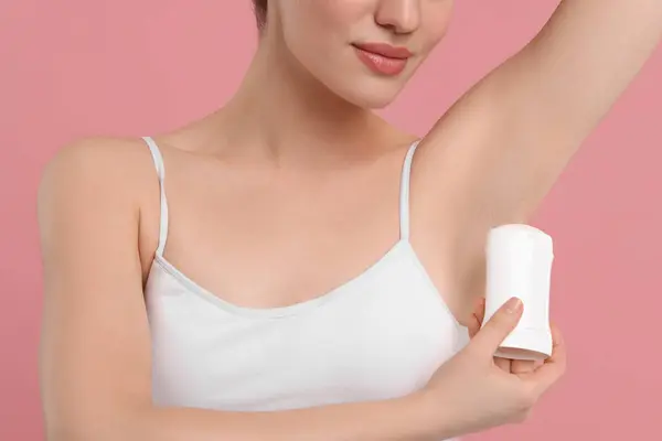 Kobieta Stosująca Dezodorant Różowym Tle Zbliżenie — Zdjęcie stockowe