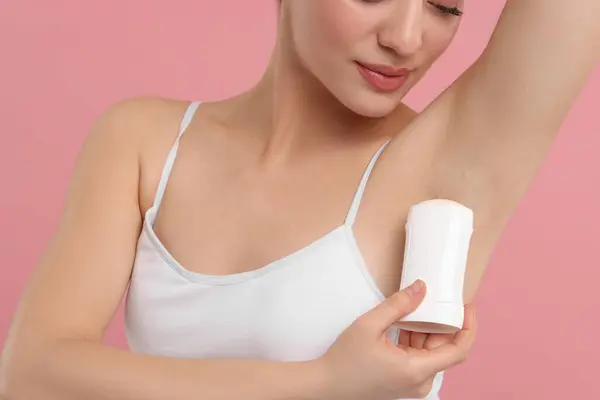 Piękna Kobieta Stosująca Dezodorant Różowym Tle — Zdjęcie stockowe