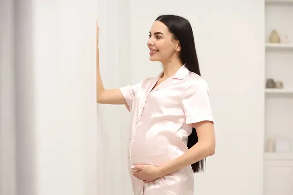 Ευτυχισμένη Έγκυος Γυναίκα Πιτζάμες Κοντά Στο Παράθυρο Εσωτερικούς Χώρους — Φωτογραφία Αρχείου