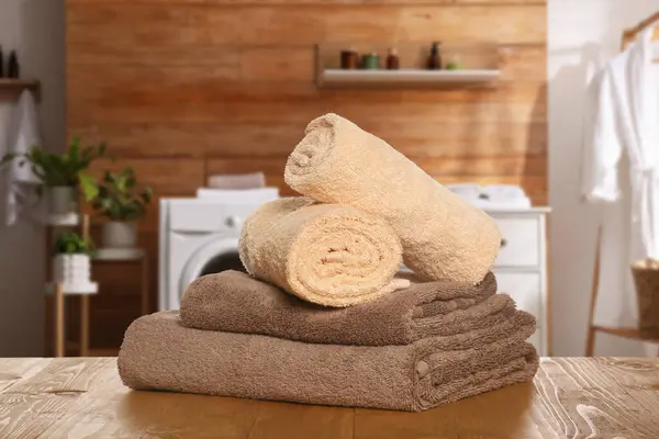 Clean towels on wooden table in laundry room