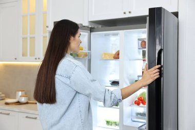 Genç kadının yanına modern mutfak buzdolabında