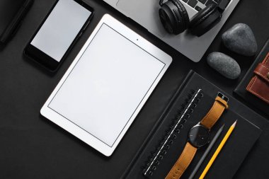 Siyah zemin üzerinde modern tablet bulunan düz kompozisyon. Metin için boşluk