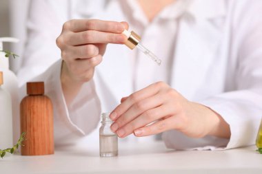 Dermatolog, beyaz masa içerisindeki temel yağı test ediyor.