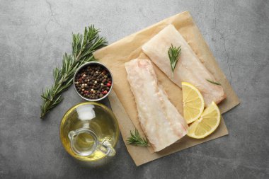 Taze çiğ balık filetosu, baharat ve limon dilimleri gri masada, düz yerde.