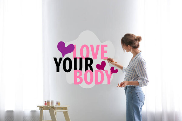 Женщина пишет слова Love Your Body и рисует сердца на стене дома