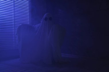 Ürkütücü hayalet. Pencerenin yanındaki mavi ışıkla örtülü kadın, metin için boşluk