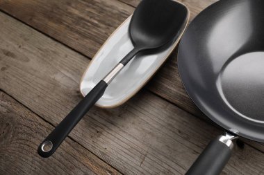 Kara metal tava ve spatula ahşap masanın üstünde.