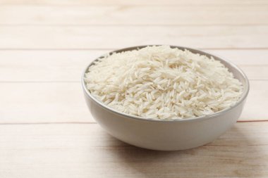 Beyaz ahşap masada, kasede çiğ basmati pilavı.