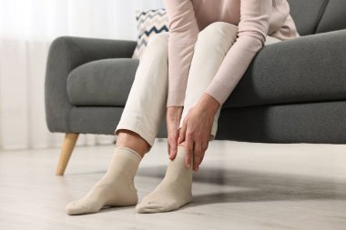 Artrit belirtileri. Evinde bacağı ağrıyan bir kadın, yakın plan.