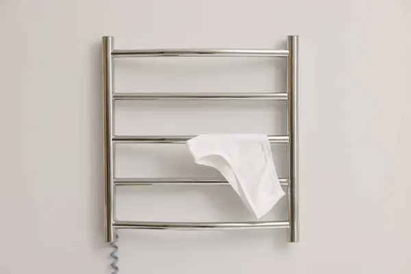 Heated towel rail with underwear on white wall