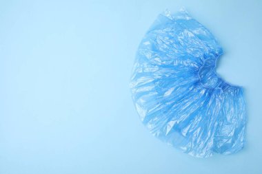 Açık mavi arka planda bir çift tıbbi ayakkabı kılıfı, üst manzara. Metin için boşluk