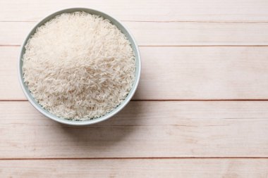 Tabakta çiğ basmati pilavı, beyaz ahşap masa, üst manzara. Metin için boşluk