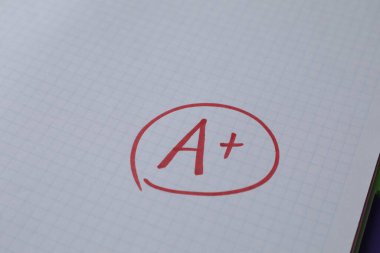 Okul derecesi. Not defteri kağıdında artı işareti olan kırmızı harf A, kapat