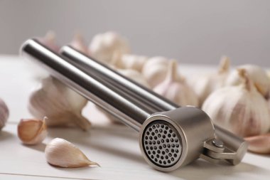 Metal pres ve sarımsak beyaz masada, yakın plan.