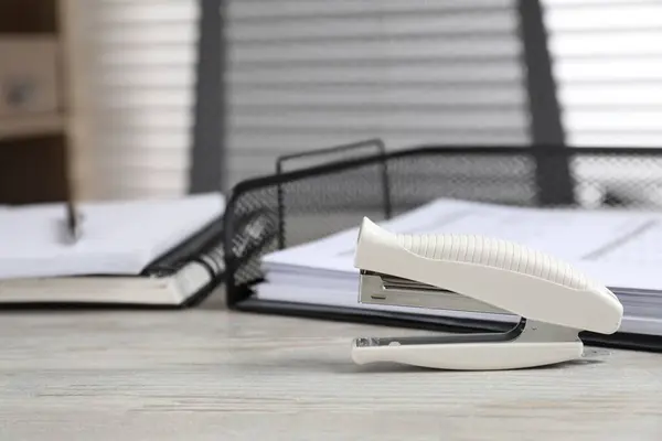 Stapler on wooden table indoors, space for text. Office stationery