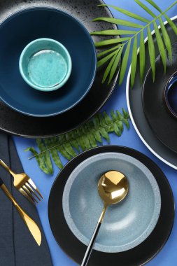 Mavi zemin üzerinde şık seramik plakalar ve çiçek dekoru ile düz konum