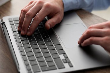 E-öğrenme. Çevrimiçi ders sırasında masadaki bilgisayarı kullanan adam, yakın plan.