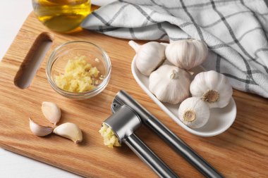 Üzerinde metal pres ve ezilmiş sarımsak olan masa, yakın plan.