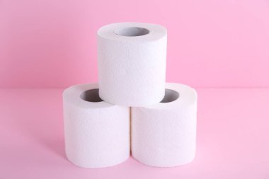 Pembe arka planda yumuşak tuvalet kağıdı ruloları, yakın plan