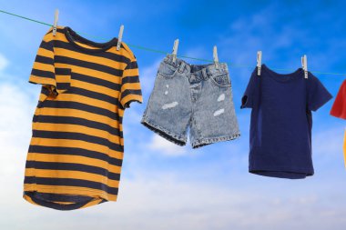 Different clothes drying on washing line against blue sky