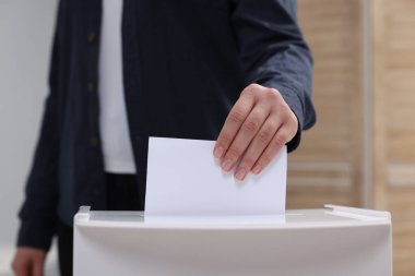 Kadın oyunu puslu arka planda sandığa koyuyor, yakın plan.