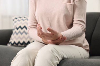 Artrit belirtileri. Kadın evinde bilek ağrısı çekiyor, yakın plan.