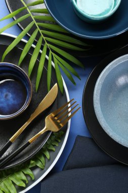 Mavi zemin üzerinde şık seramik plakalar ve çiçek dekoru ile düz konum