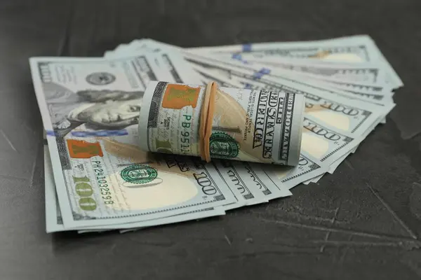 Money exchange. Dollar banknotes on dark gray textured background, closeup