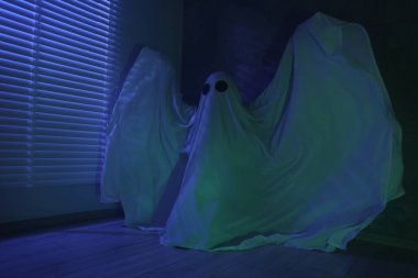 Ürkütücü hayalet. Pencerenin yanında, mavi ışıkla kaplanmış kadın.