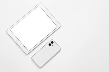 Beyaz arka planda modern tablet ve akıllı telefon, düz konum. Metin için boşluk