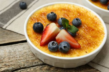 Böğürtlenli ve nane şekerli nefis creme brulee ahşap masada, yakın plan