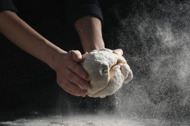 Ekmek yapıyorum. Masada hamur yoğuran kadın, yakın plan.