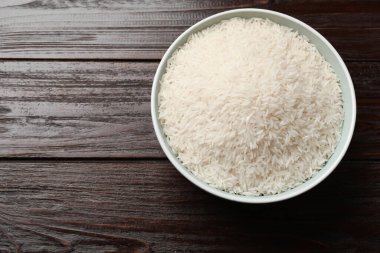 Tabakta çiğ basmati pilavı, ahşap masa, üst manzara. Metin için boşluk