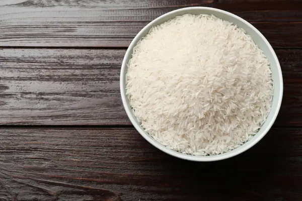 Tabakta çiğ basmati pilavı, ahşap masa, üst manzara. Metin için boşluk