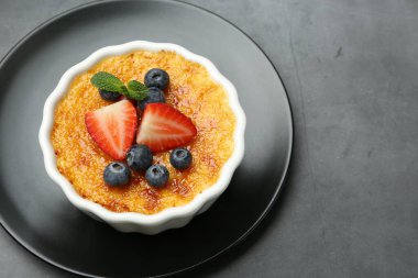 Manzaranın üstünde, gri masada, böğürtlenli ve nane şekerli nefis creme brulee. Metin için boşluk
