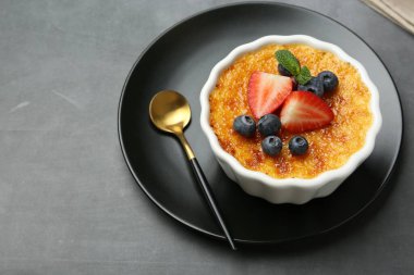 Böğürtlenli ve naneli nefis creme brulee. Gri masada, yakın plan. Metin için boşluk