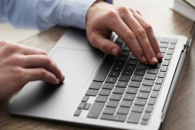 E-öğrenme. Çevrimiçi ders sırasında masadaki bilgisayarı kullanan adam, yakın plan.