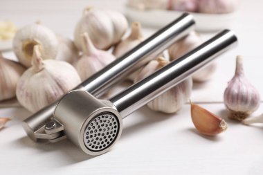 Metal pres ve sarımsak beyaz masada, yakın plan.