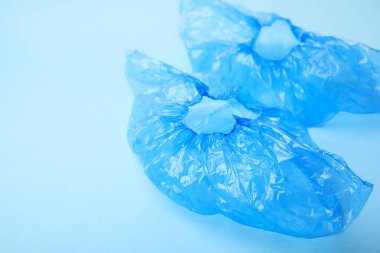 Açık mavi arkaplanda bir çift tıbbi ayakkabı kapağı, metin için boşluk