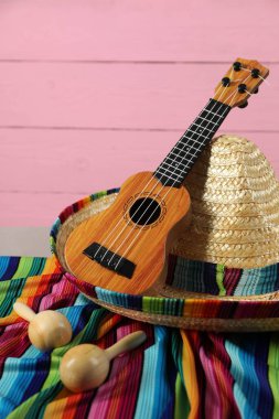 Meksika şapkası, marakas ve ukulele masada, yakın plan.