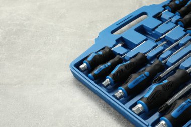 Gri desenli masadaki açık alet çantasındaki tornavidalar, yakın plan. Metin için boşluk